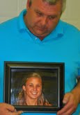 Talbot Elkins holding a photo of his daughter Jessica