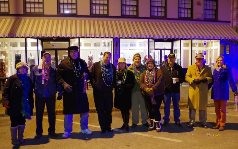 : Athens State President Bob Glenn and Laurie Glenn (right) with revelers at last year’s Mardi Gras parade celebration.