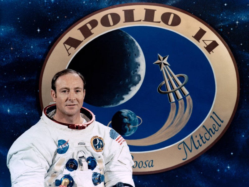 Apollo astronaut Edgar Mitchell in front of a graphic of the mission patch. Credits: NASA