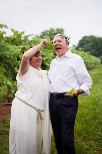  Athena-Grease Goddess Marlene Isom and Athens Mayor Ronnie Marks exemplify the quirky fun aspect of the Athens Grease Festival as they joke around in the Isom's Orchard grape vines.