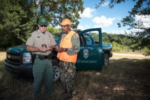  A Conservation Enforcement Officer shows a hunter how to use Game Check on his smartphone.